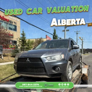 Dark grey Mitsubishi Outlander SUV on a flatbed trailer in Alberta. Text: USED CAR VALUATION, 587-844-2274.