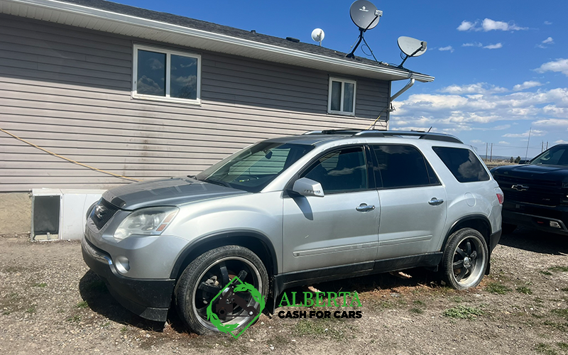 Silver SUV parked beside a house on a sunny day with Alberta Cash for Cars branding