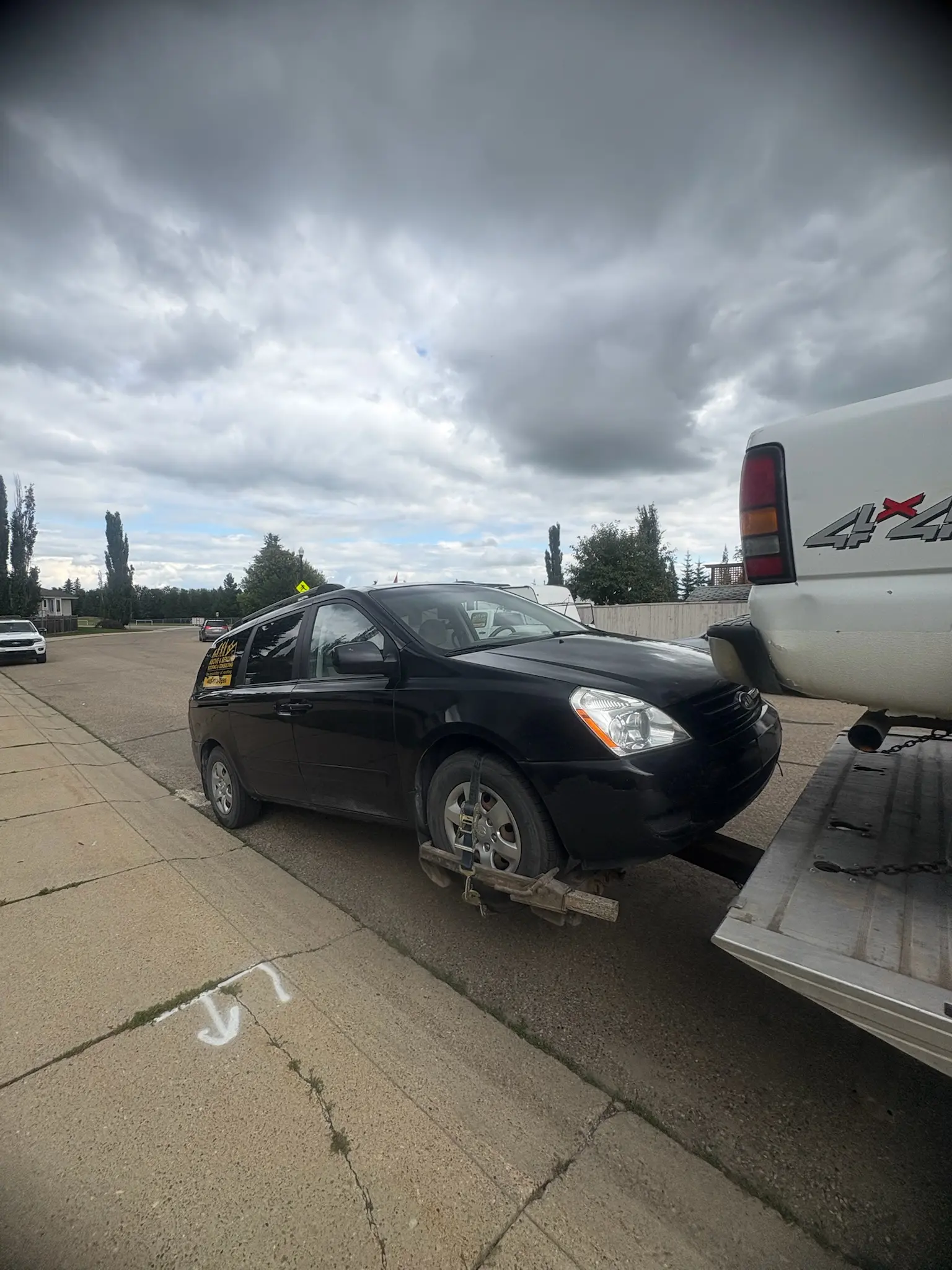 Alberta Cash for Cars team loading a sold vehicle onto a flatbed tow truck